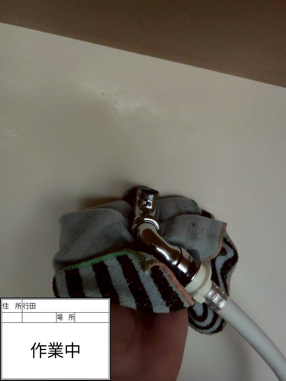 行田市 洗濯機水栓のナット取り外し時に蛇口を固定している様子